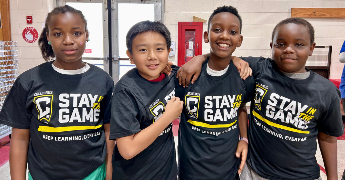 students standing shoulder to shoulder wearing stay in the game shirts
